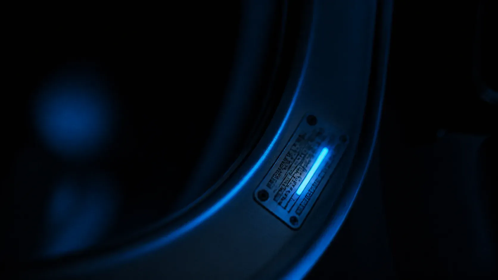 Close-up of a rating plate in an appliance door frame; the model-number line is highlighted in blue